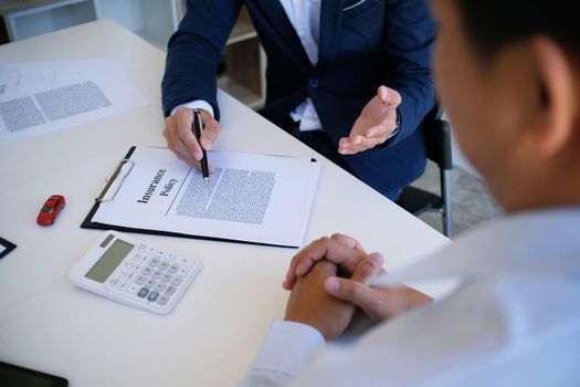 Sales manager giving advice application form document, considering mortgage loan offer for car and house insurance