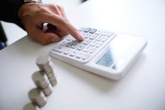 Accountant verify the business and saving money stacking gold coins with calculator. Accountancy Concept.