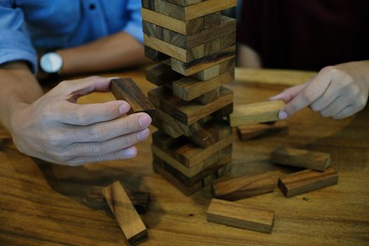 Group of Friends playing blocks wood game on the table folded puzzle