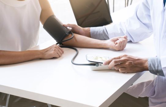 Doctor checking old woman patient arterial blood pressure. Health care