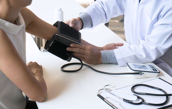 Doctor checking old woman patient arterial blood pressure. Health care