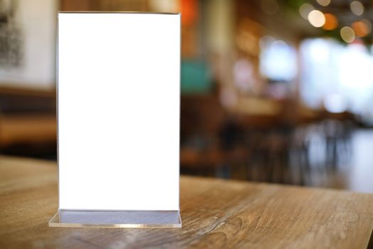 Mock up Menu frame standing on wood table in Bar restaurant cafe. space for text.