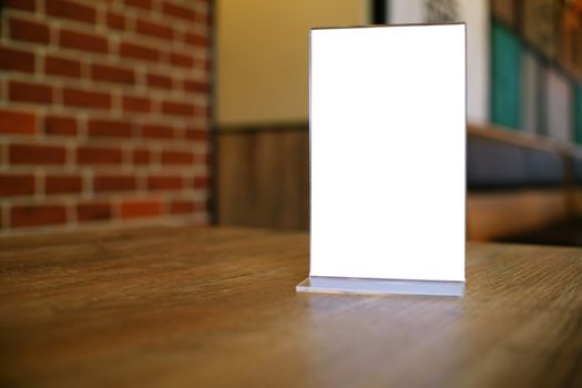 Mock up Menu frame standing on wood table in Bar restaurant cafe. space for text.