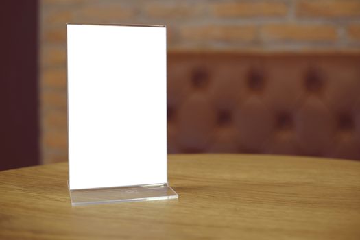 Mock up Menu frame standing on wood table in Bar restaurant cafe. space for text.