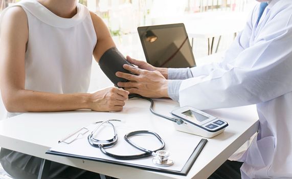 Doctor checking old woman patient arterial blood pressure. Health care.