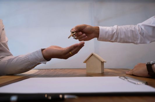 Real estate agent giving keys to customer after contract signature