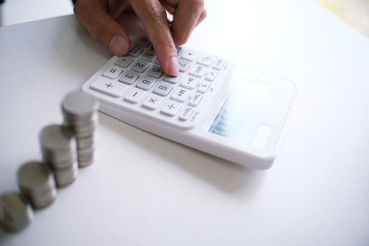 Accountant verify the business and saving money stacking gold coins with calculator. Accountancy Concept.