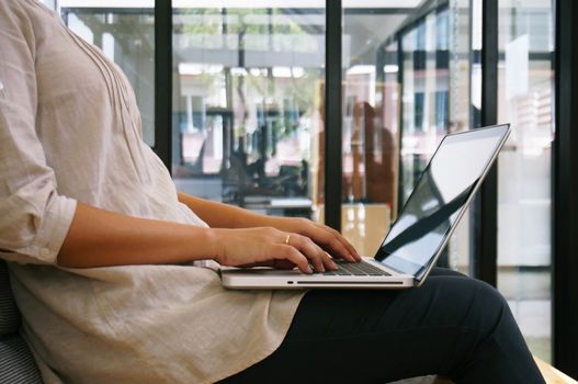 The Casual business woman works online on laptop which hand on keyboard in her house Isolated screen in laptop