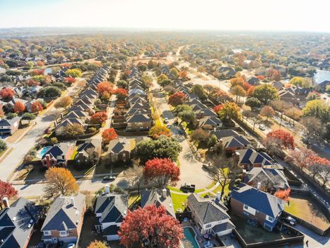 Top drone view lakeside residential neighborhood with cul-de-sac (dead-end) in North of Dallas, Texas, USA during fall season. Row of single-family houses subdivision with colorful autumn leaves