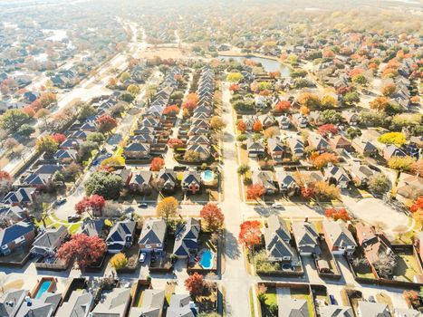 Top drone view lakeside residential neighborhood with cul-de-sac (dead-end) in North of Dallas, Texas, USA during fall season. Row of single-family houses subdivision with colorful autumn leaves