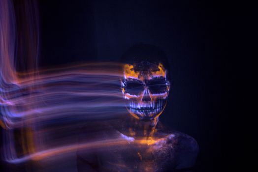 Girl's Face painted in fluorescent UV colors and looks like Neon Glowing Skull