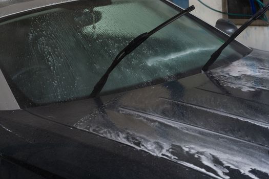 Manual car wash with pressurized water in the car wash outside.