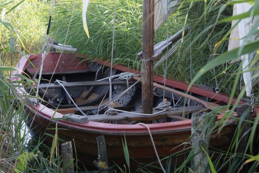 Wooden boat on the shore of a lake in the reeds              