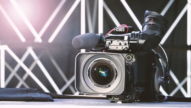 Blurry images of broadcast camera on the crane tripod for easy to shooting or recording and broadcasting content in studio production to on air tv or online internet live show.