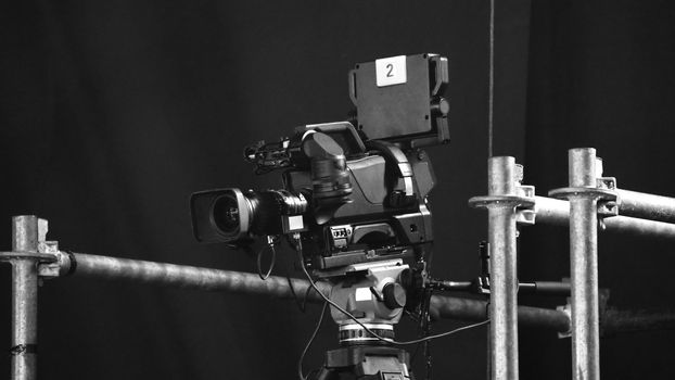 Blurry images of broadcast camera on the crane tripod for easy to shooting or recording and broadcasting content in studio production to on air tv or online internet live show.
