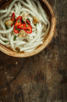 closeup of udon noodle in wood bowl on wooden floor background