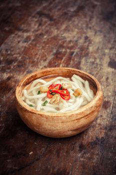 closeup of udon noodle in wood bowl on wooden floor