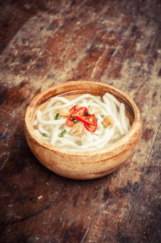 closeup of udon noodle in wood bowl on wooden floor