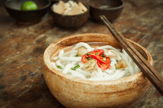 closeup of udon noodle in wood bowl on wooden floor