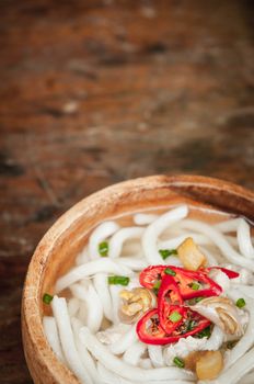 closeup of udon noodle in wood bowl on wooden floor background