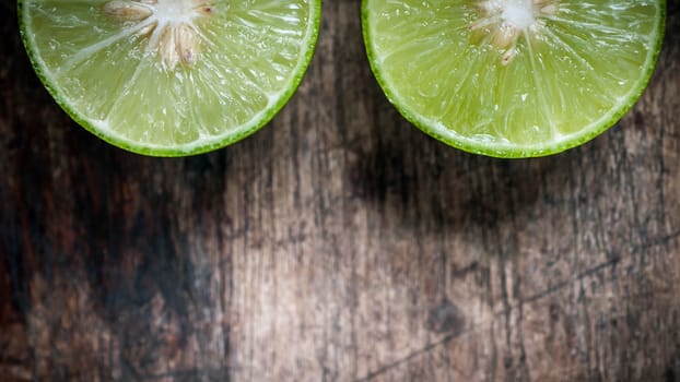 Green Lemon cut on wooden background