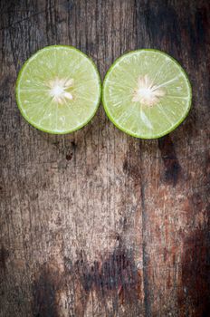 Green Lemon cut on wooden background