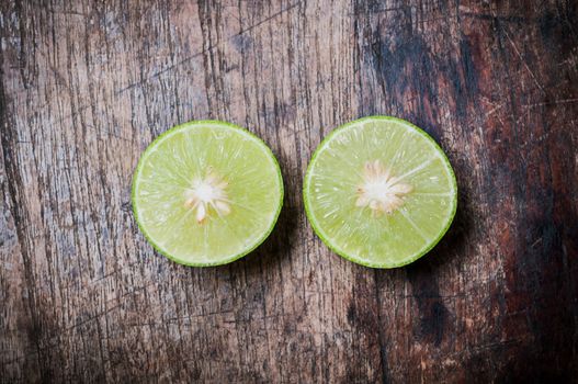 Green Lemon cut on wooden background
