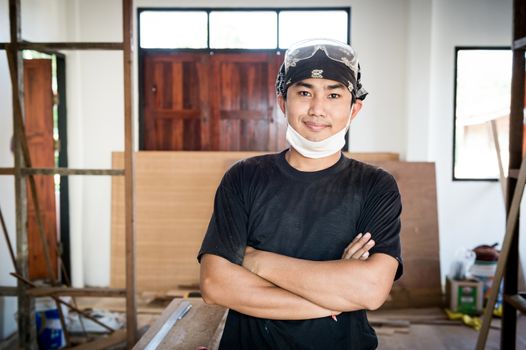 Young male carpenter portrait in workshop interior