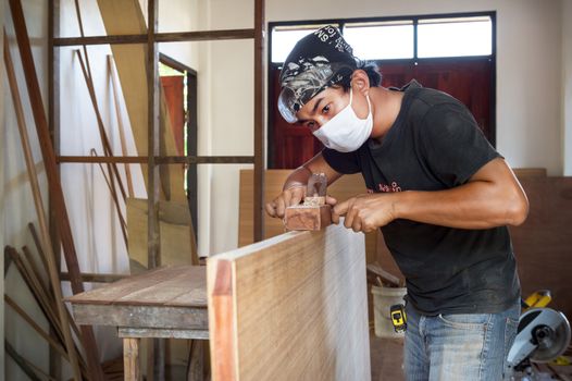 carpenter man use planer making a wood door