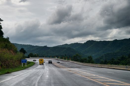 road on mountain with clouds sky