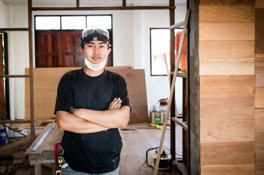 Young male carpenter portrait in workshop interior