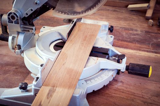 Machine saw cutting a wood plank closeup