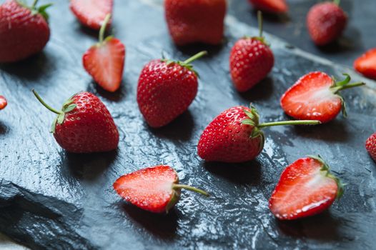 Strawberry fruit on black stone background