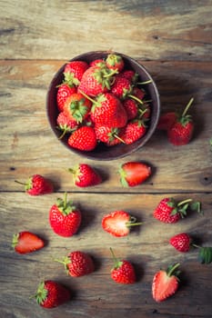 strawberry fruit in wood cup on grunge wooden background