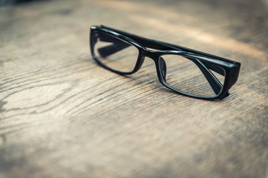 closeup of eye glasses on wooden floor