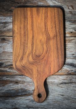 Chopping board on wooden plank background