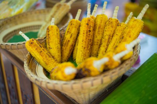 closeup of grilled corn in wood basket, food stylish of asian culture.