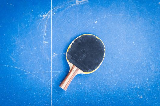 racket of table tennis on blue table background