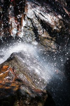 Closeup of waterfall and rock in forest