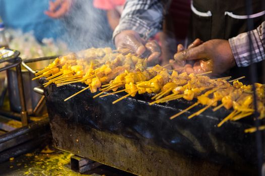 Close-up of the chef's hands are grilled pork skewers