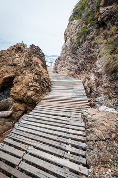 Wooden pathway with rock valley or cliff on the island