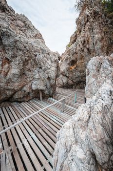 Wooden pathway with rock valley or cliff on the island