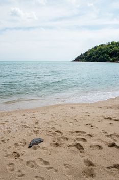 Closeup of footprint on the beach with mountain