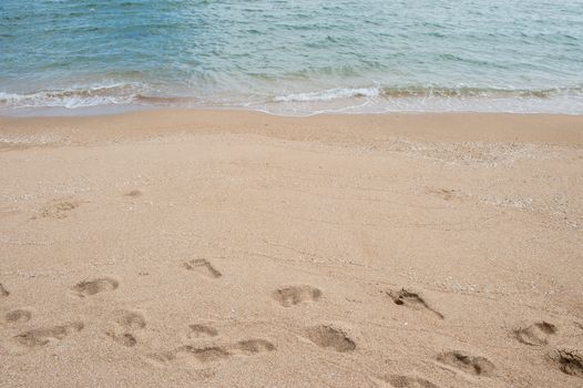 Background of footprint on the beach with sea wave