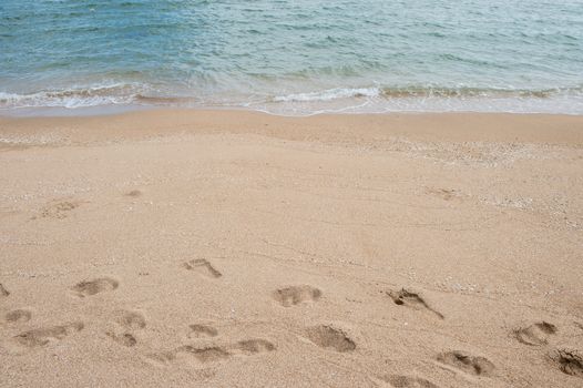 Background of footprint on the beach with sea wave