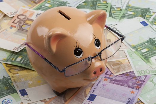 Piggy Bank With Euro Banknotes and Blue Glasses