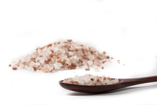 Himalayan Salt Raw Crystals Pile with Brown Wood Spoon Isolated on White Background