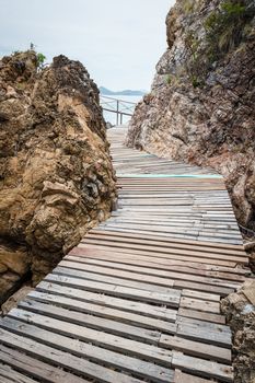 Wooden pathway with rock valley or cliff on the island