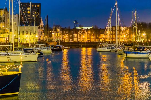 The harbor of Vlissingen at night, decorated boats with lights, lighted city buildings, popular city in zeeland, the Netherlands