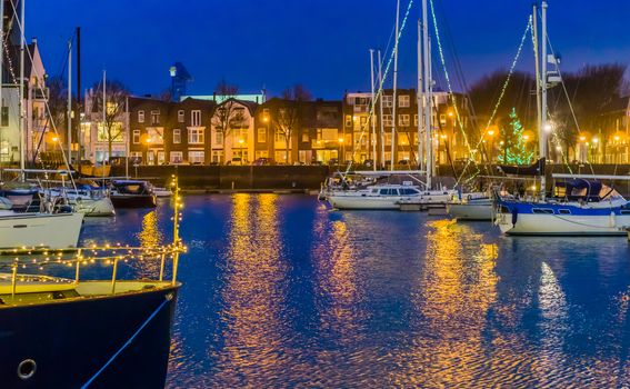 The port of Vlissingen at night, decorated ships with lights, lighted city buildings with water, popular city in zeeland, The Netherlands